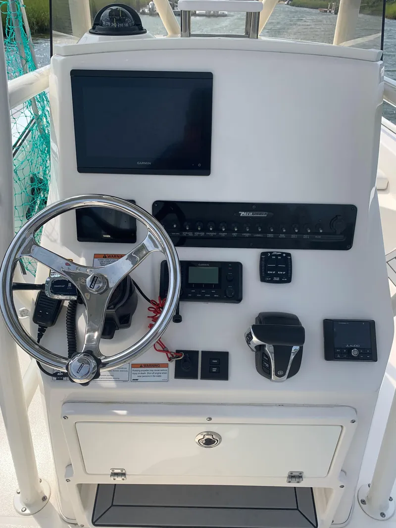 Slide: The Image of 2021 Pathfinder 2600 TRS boat console with steering wheel and navigation equipment. - 11