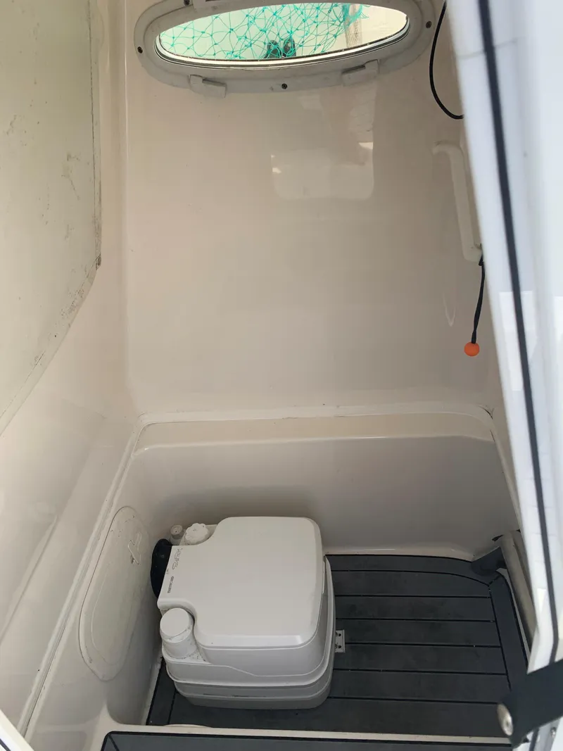 Slide: The Image of 2021 Pathfinder 2600 TRS boat interior with portable toilet and window. - 18