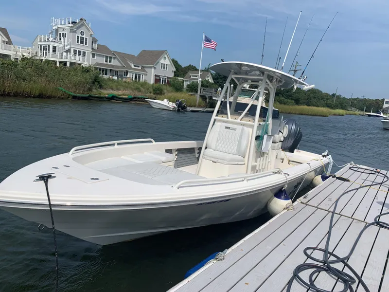 Slide: The Image of 2021 Pathfinder 2600 TRS boat docked near waterfront homes. - 2