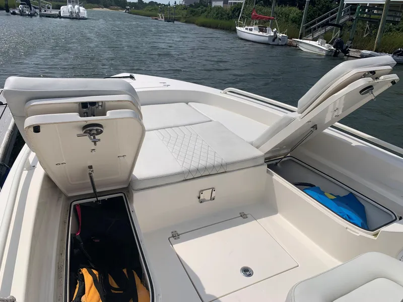 Slide: The Image of 2021 Pathfinder 2600 TRS boat with open storage compartments on a sunny day. - 20