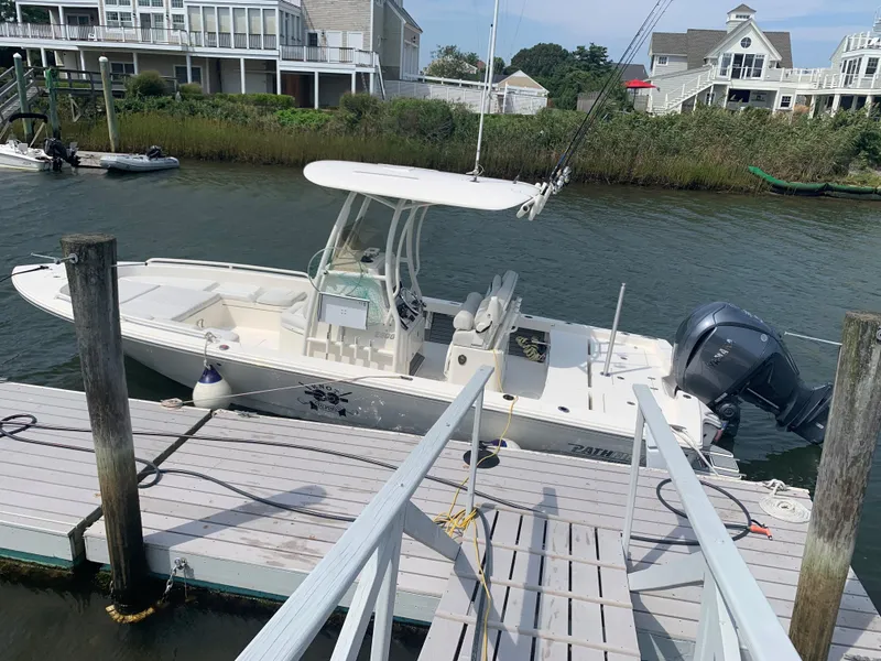 Slide: The Image of 2021 Pathfinder 2600 TRS boat docked near waterfront homes. - 3