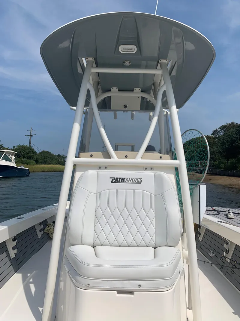 Slide: The Image of 2021 Pathfinder 2600 TRS boat with white seating and T-top on calm water. - 9