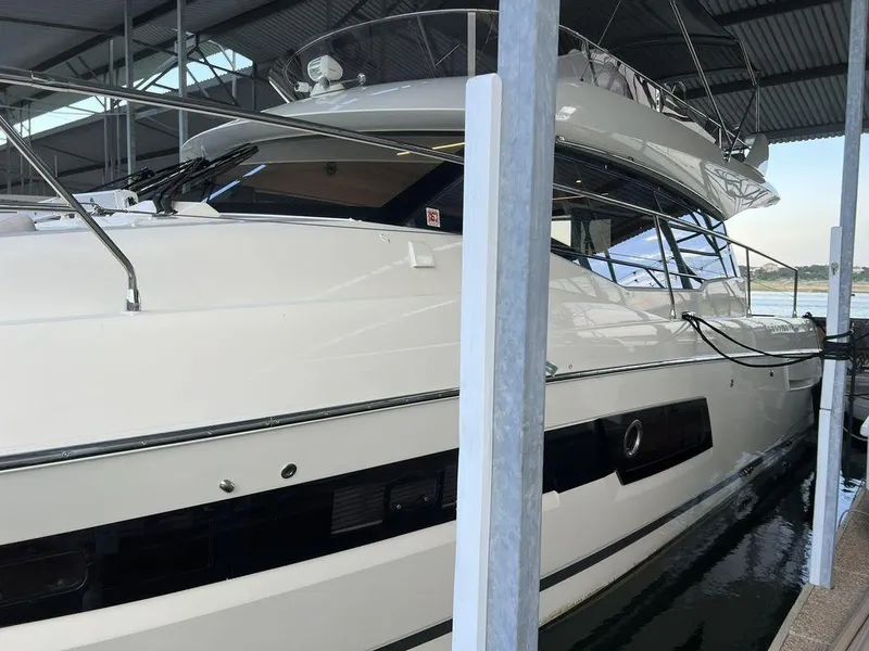 Slide: The Image of Prestige 460F 2022 yacht docked in a marina under a covered shelter. - 13