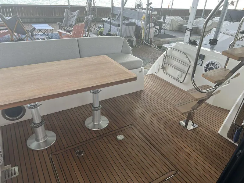 Slide: The Image of Prestige 460F 2022 yacht deck with wooden flooring and seating area. - 25