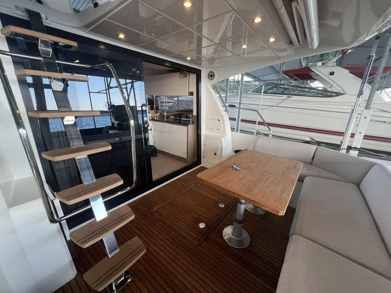 Slide: The Image of Luxury yacht interior with wooden deck, modern staircase, and seating area on a 2022 Prestige 460F. - 29