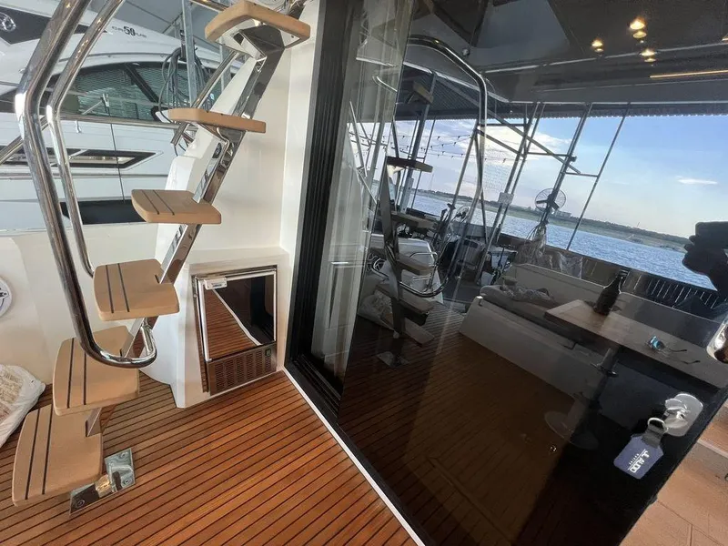 Slide: The Image of Prestige 460F 2022 yacht interior with wooden stairs and glass doors, overlooking the water. - 31