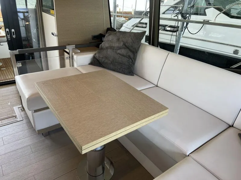 Slide: The Image of Luxurious 2022 Prestige 460F yacht interior with white seating and wooden table. - 33