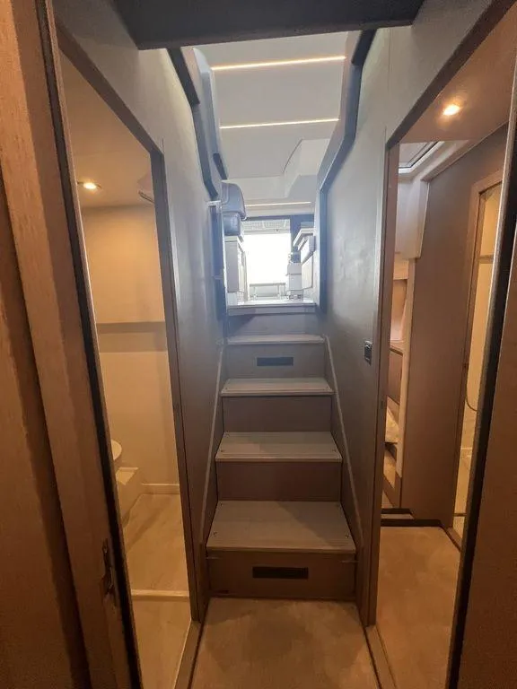 Slide: The Image of Interior of 2022 Prestige 460F yacht, featuring modern staircase and elegant wood finishes. - 34