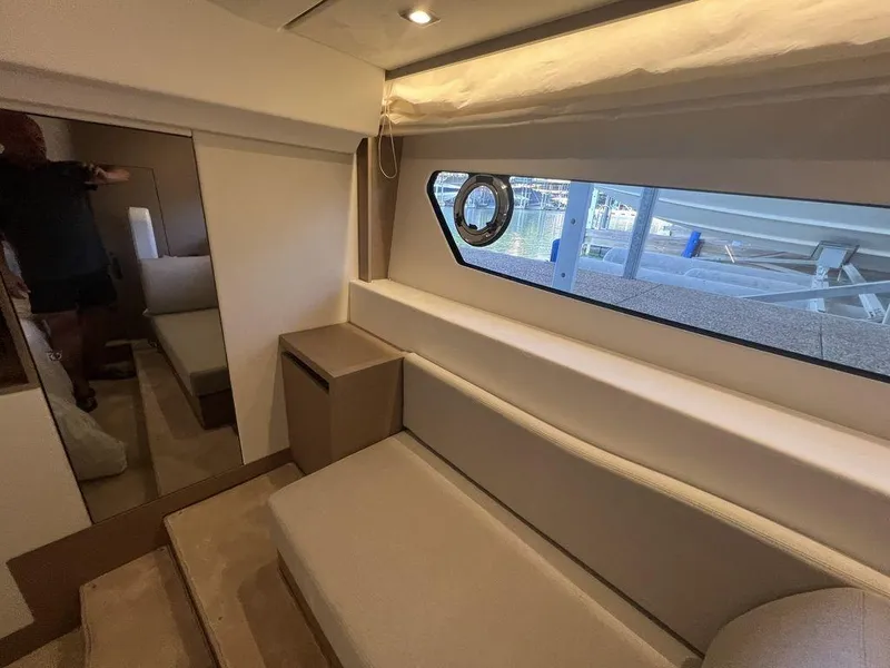 Slide: The Image of Interior of 2022 Prestige 460F yacht, featuring modern seating and window view. - 43