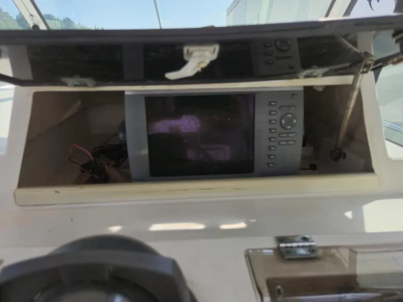 Slide: The Image of 1990 Grady-White 230 Gulfstream boat dashboard with electronic equipment compartment open. - 12