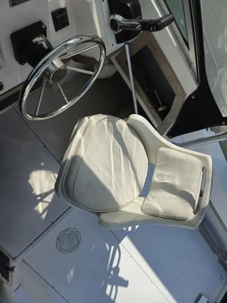 Slide: The Image of 1990 Grady-White 230 Gulfstream boat cockpit with steering wheel and seat. - 14