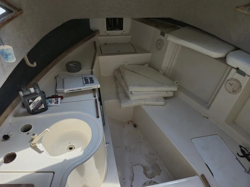 Slide: The Image of Interior of a 1990 Grady-White 230 Gulfstream boat, featuring a compact cabin layout. - 15