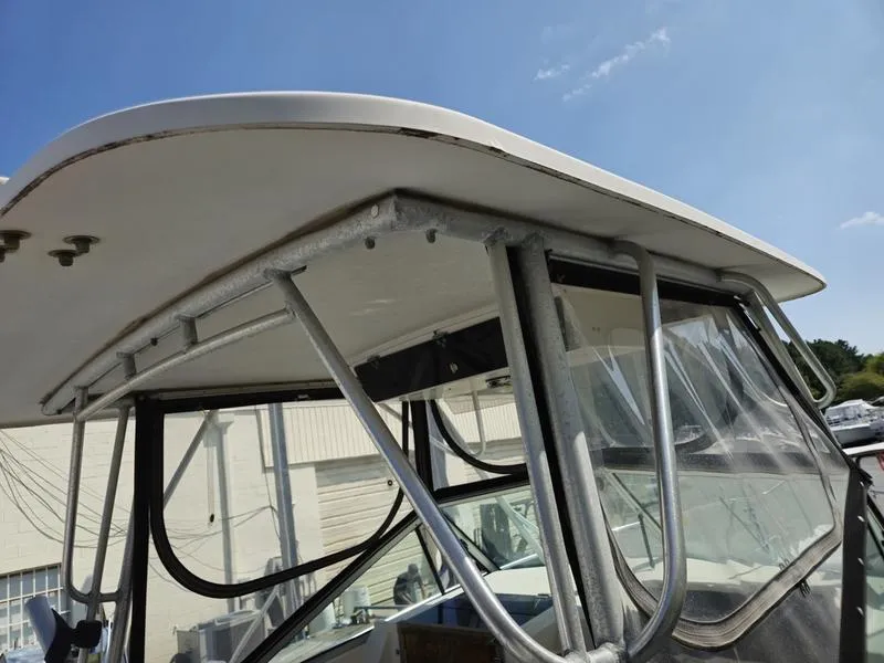 Slide: The Image of 1990 Grady-White 230 Gulfstream boat with metal frame and clear windshield under blue sky. - 19