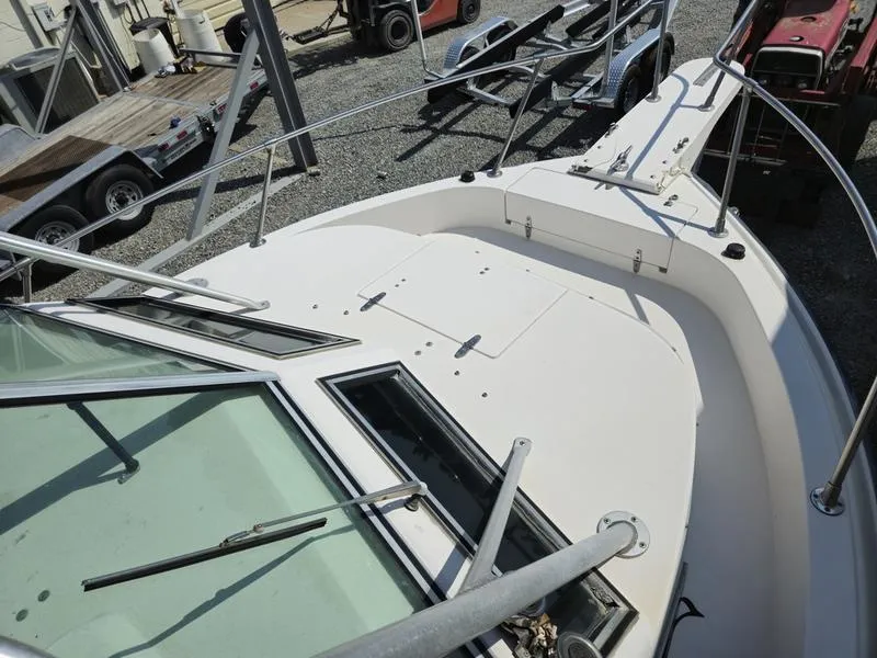 Slide: The Image of 1990 Grady-White 230 Gulfstream boat deck with windshield and railing, docked on gravel. - 20