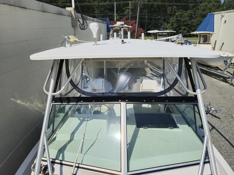 Slide: The Image of 1990 Grady-White 230 Gulfstream boat with enclosed cabin and windshield, docked outdoors. - 22