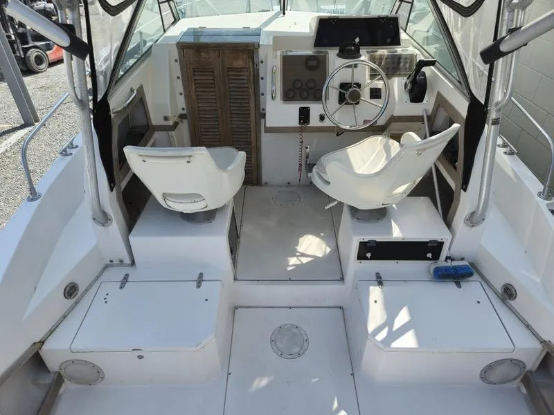 Slide: The Image of 1990 Grady-White 230 Gulfstream boat interior with helm, seating, and control panel. - 7