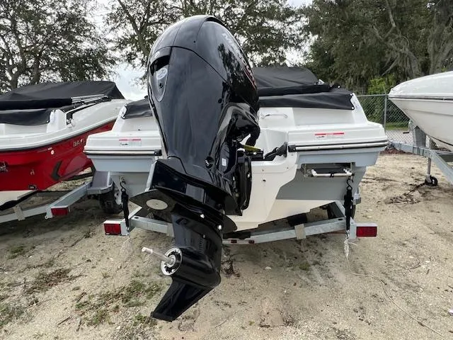 Slide: The Image of 2025 Bayliner VR4 Bowrider OB with outboard motor, parked on a sandy surface. - 1