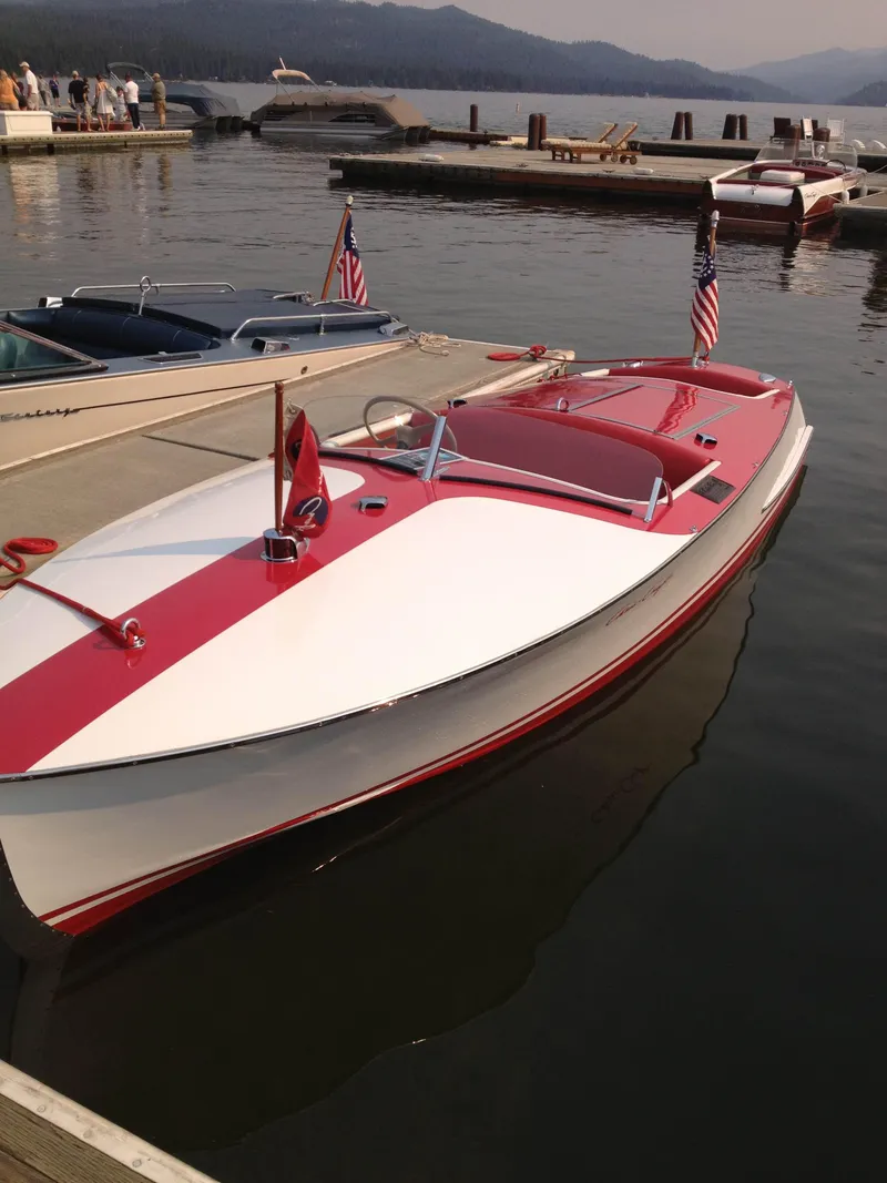 The Image of 1948 Chris-Craft Racer boat docked on calm water, featuring red and white design. - 1