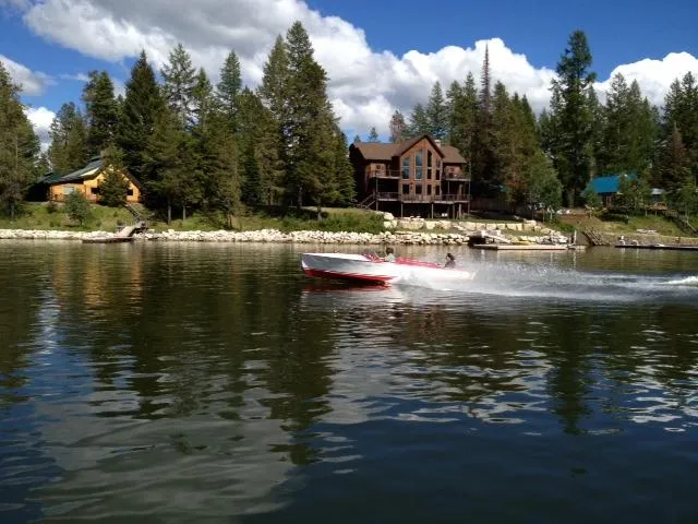 Slide: The Image of 1948 Chris-Craft Racer speeding on a scenic lake with forested shoreline and houses. - 10