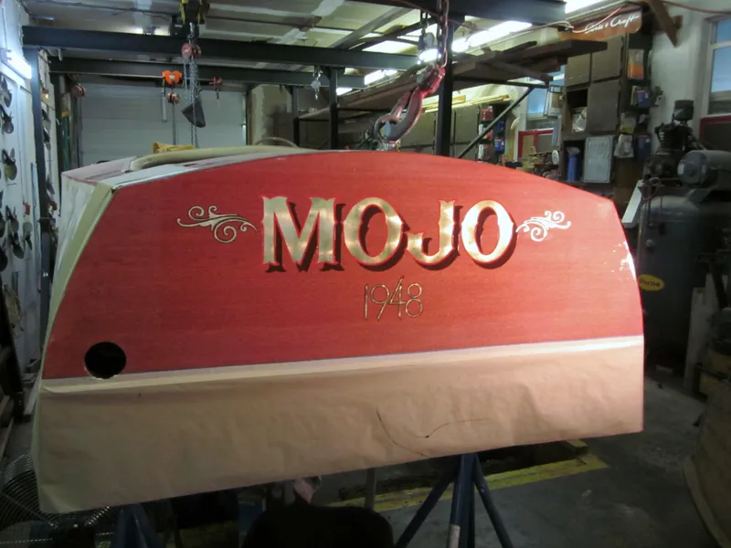 Slide: The Image of 1948 Chris-Craft Racer boat with "MOJO" name in workshop setting. - 17