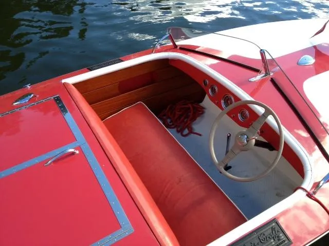 Slide: The Image of 1948 Chris-Craft Racer boat with red interior, wooden dashboard, and classic steering wheel. - 8