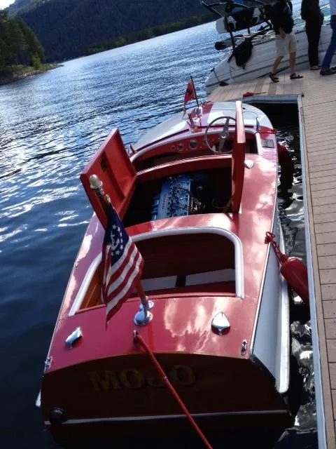 Slide: The Image of 1948 Chris-Craft Racer boat docked on a serene lake with American flag. - 9