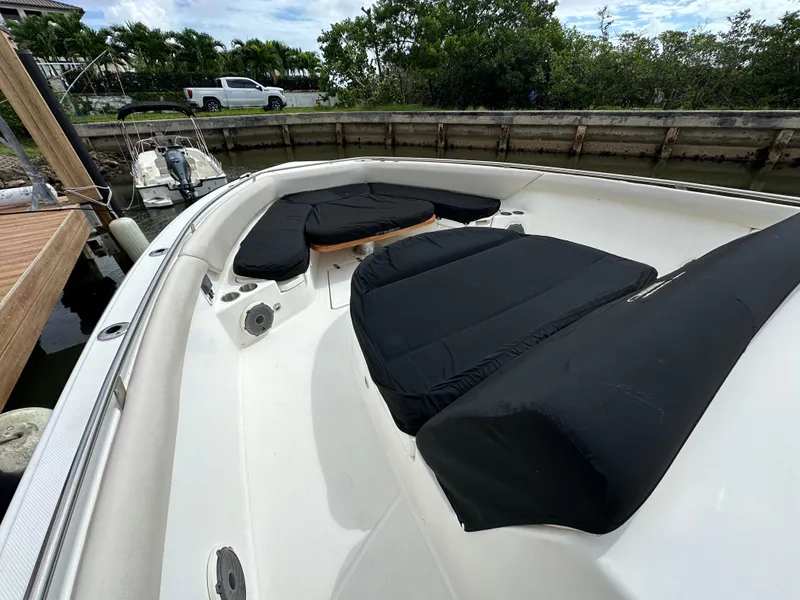 Slide: The Image of 2020 Boston Whaler 420 Outrage boat with black cushioned seating in docked position. - 12