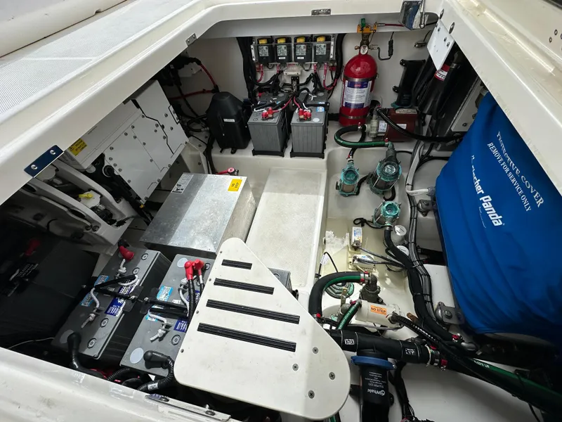 Slide: The Image of Engine compartment of 2020 Boston Whaler 420 Outrage, showcasing batteries and equipment. - 18