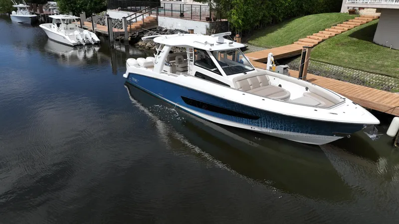 Slide: The Image of 2020 Boston Whaler 420 Outrage boat docked in a serene waterway. - 2