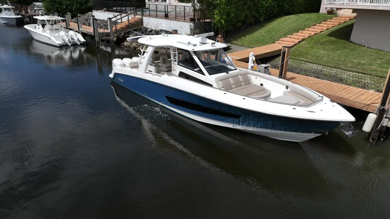 Slide: The Image of 2020 Boston Whaler 420 Outrage boat docked in a serene canal. - 3