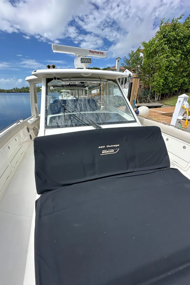 Slide: The Image of 2020 Boston Whaler 420 Outrage boat docked by the water. - 35