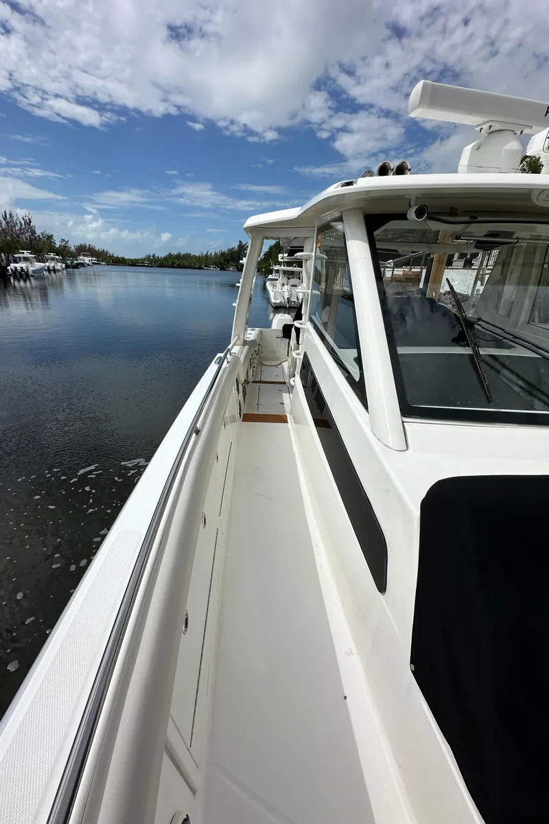 Slide: The Image of 2020 Boston Whaler 420 Outrage boat on calm water under blue sky. - 36