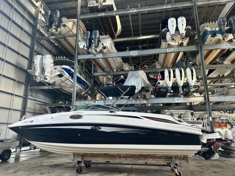 Slide: The Image of 2011 Sea Ray 280 Sundeck in indoor storage with stacked boats. - 0