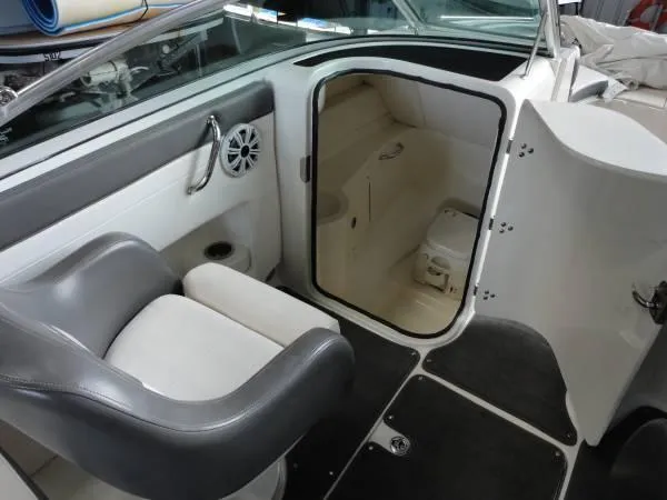 Slide: The Image of 2011 Sea Ray 280 Sundeck interior with seating and compact restroom. - 12