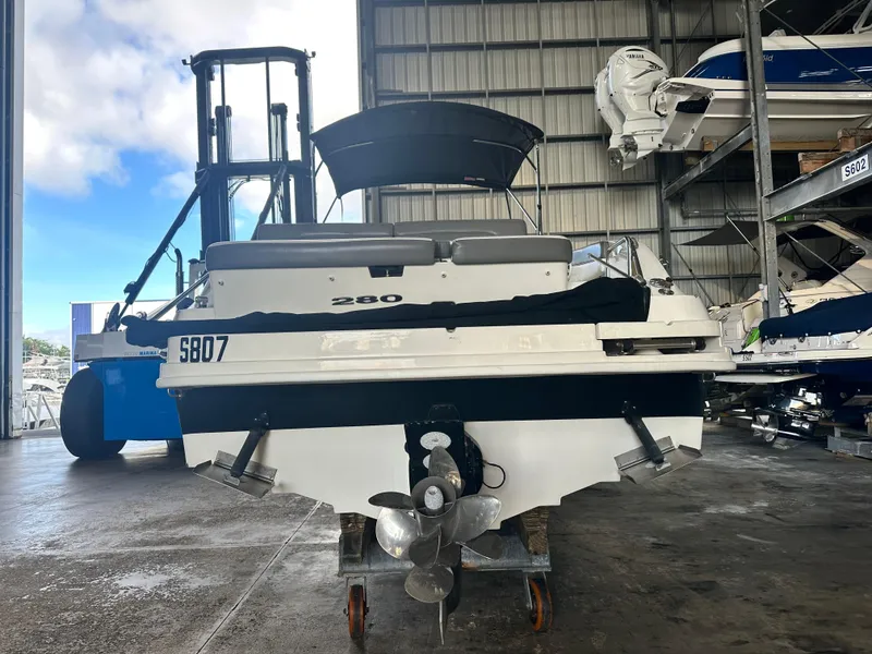 Slide: The Image of 2011 Sea Ray 280 Sundeck in storage, rear view with propeller visible. - 21