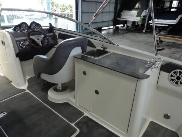 Slide: The Image of 2011 Sea Ray 280 Sundeck interior with helm, sink, and seating area. - 8