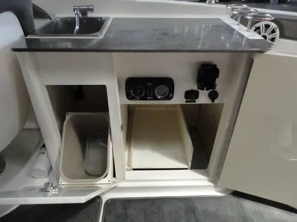 Slide: The Image of 2011 Sea Ray 280 Sundeck interior with sink, storage, and control panel. - 9