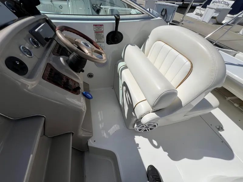 Slide: The Image of 2001 Sea Ray 270 Sundancer helm with steering wheel and white captain's seat. - 14
