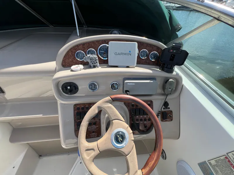 Slide: The Image of 2001 Sea Ray 270 Sundancer helm with Garmin navigation system and wood-accented steering wheel. - 15