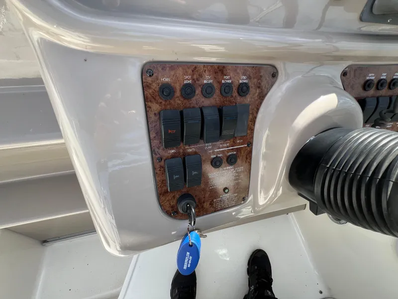 Slide: The Image of Control panel of a 2001 Sea Ray 270 Sundancer boat with key and switches. - 16