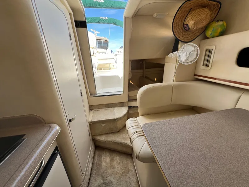 Slide: The Image of Interior of 2001 Sea Ray 270 Sundancer with seating, table, and cabin access. - 23
