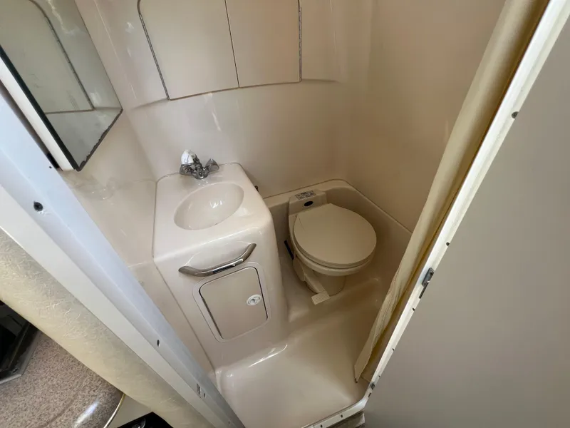 Slide: The Image of Compact bathroom in 2001 Sea Ray 270 Sundancer boat, featuring sink and toilet. - 24