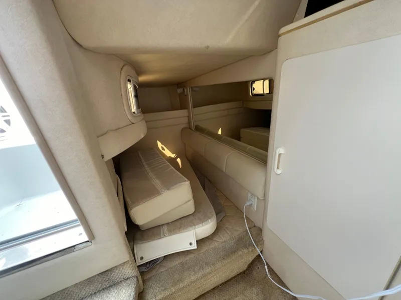 Slide: The Image of Interior cabin of 2001 Sea Ray 270 Sundancer boat, featuring beige upholstery. - 27