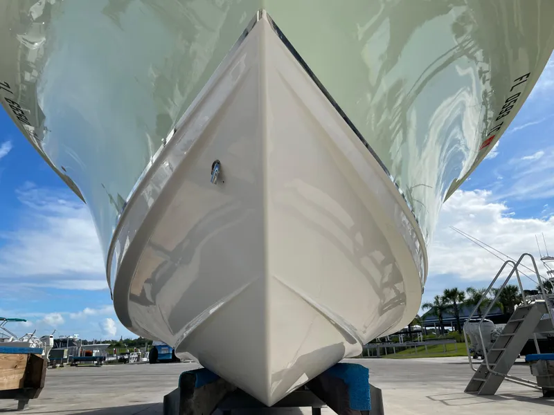 Slide: The Image of 2022 Sea Hunt Gamefish 25 boat hull, docked under clear blue sky. - 10