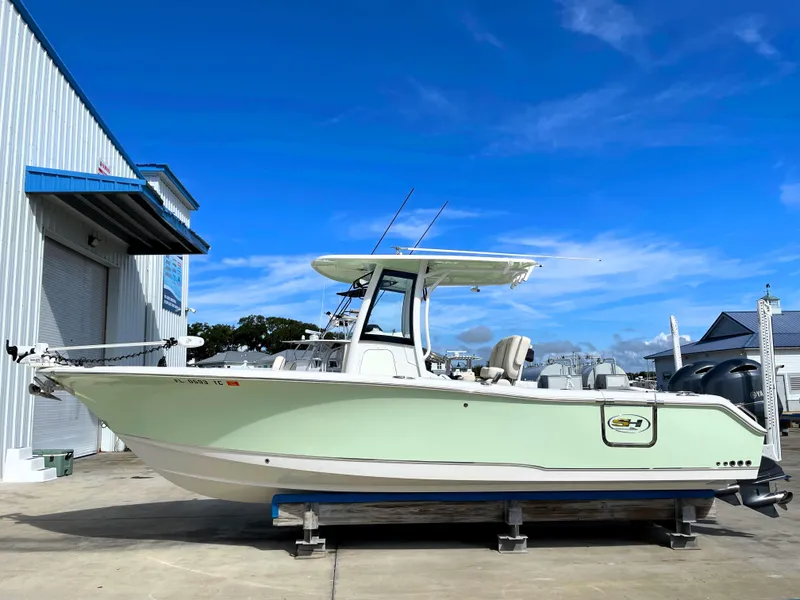 Slide: The Image of 2022 Sea Hunt Gamefish 25 boat on display at a marina under clear blue skies. - 2