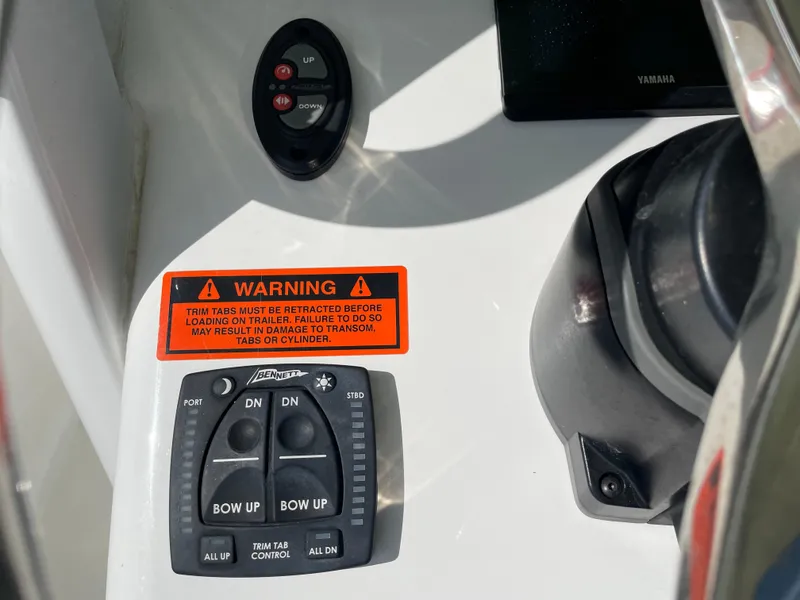 Slide: The Image of 2022 Sea Hunt Gamefish 25 control panel with warning label and trim tab controls. - 42