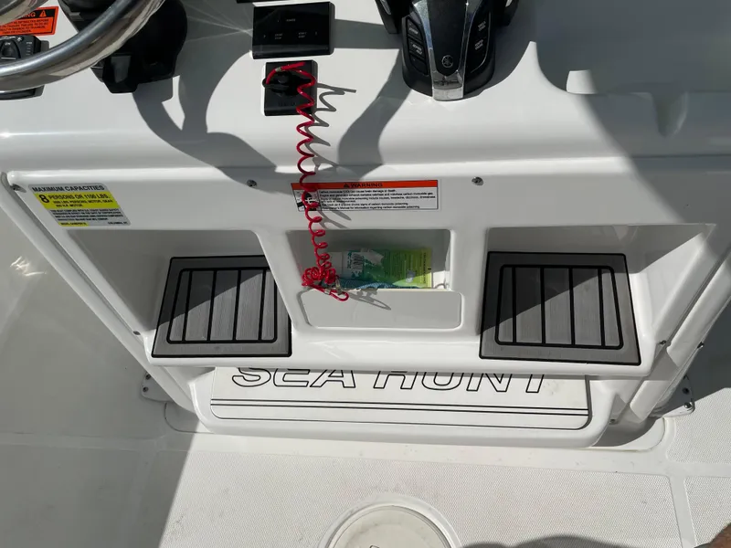 Slide: The Image of 2022 Sea Hunt Gamefish 25 boat console with steering wheel and controls. - 44