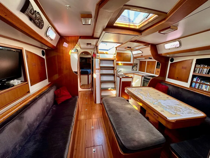Slide: The Image of Interior of 1986 Cheoy Lee Pedrick 55 Sloop, featuring wood finishes and cozy seating. - 2
