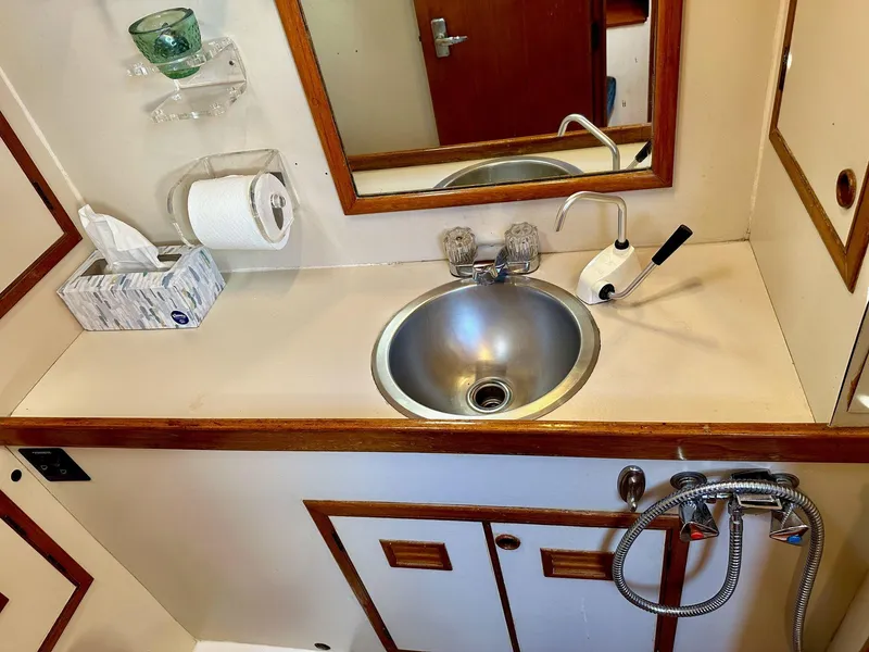 Slide: The Image of 1986 Cheoy Lee Pedrick 55 Sloop bathroom with sink, mirror, and wooden accents. - 9
