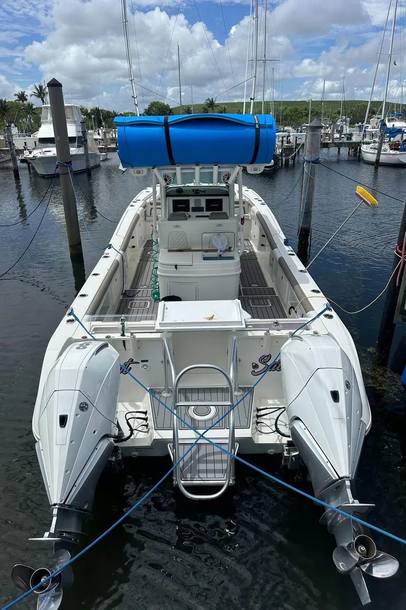 Slide: The Image of 2020 World Cat 325 CC boat docked at marina, featuring dual outboard motors. - 10